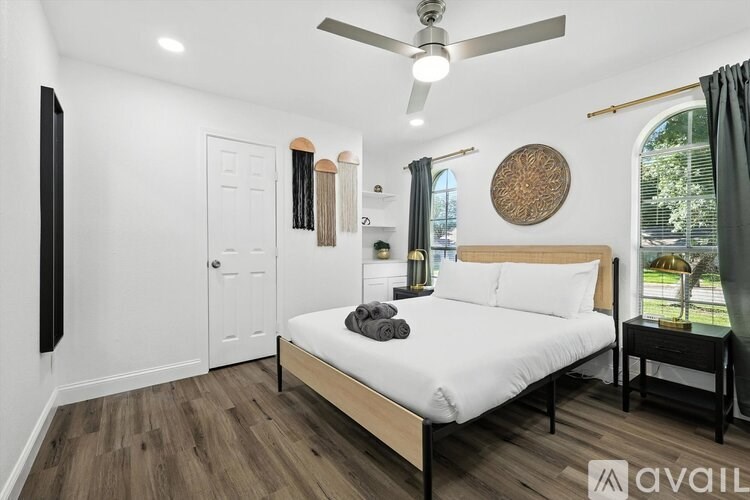 A bedroom with a bed, nightstand, and a ceiling fan.