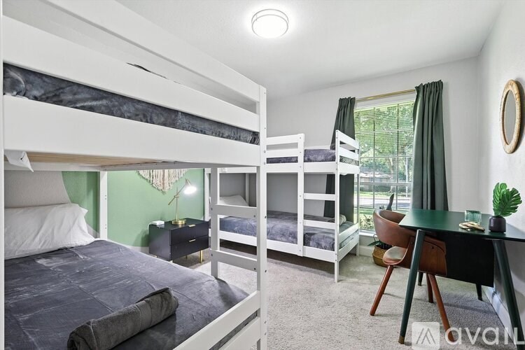 A bedroom with a bunk bed and a desk.