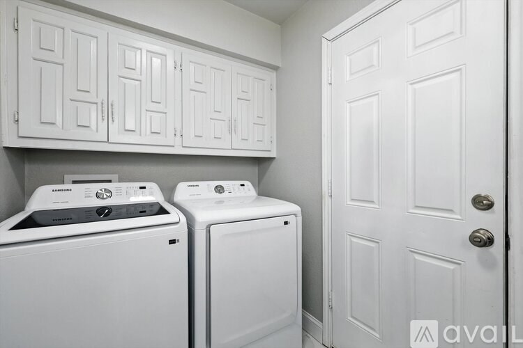A white washing machine and dryer in a laundry room.