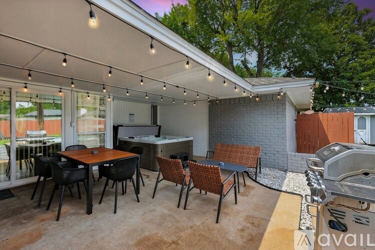 A patio with a table and chairs under a white canopy.