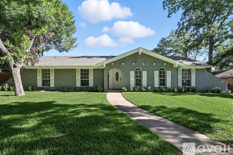 A green house with a white door and windows.