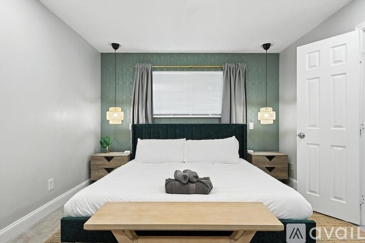 A bedroom with a bed, nightstands, and a window with curtains.