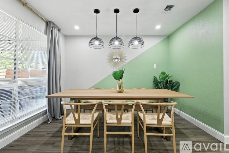 A dining room with a wooden table and chairs.