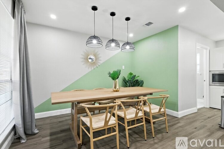 A dining room with a wooden table and chairs.