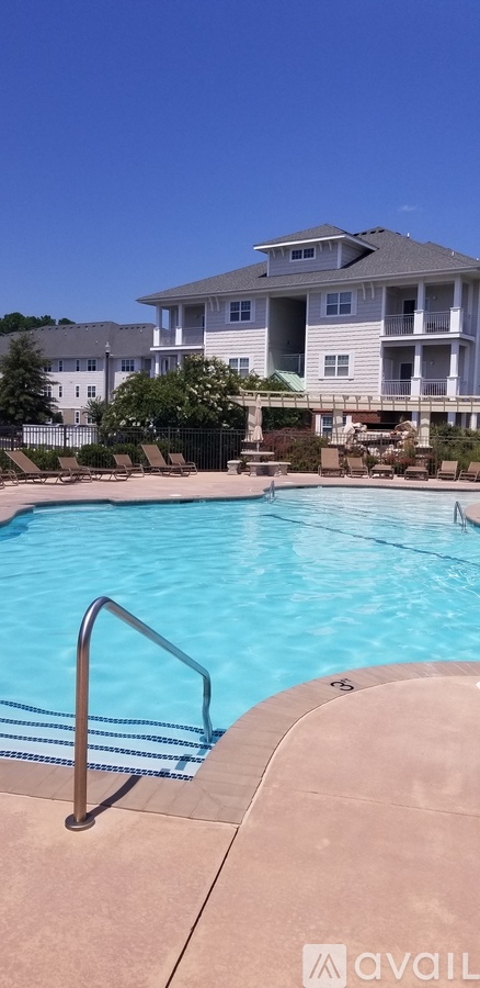 A swimming pool in front of a large apartment building.