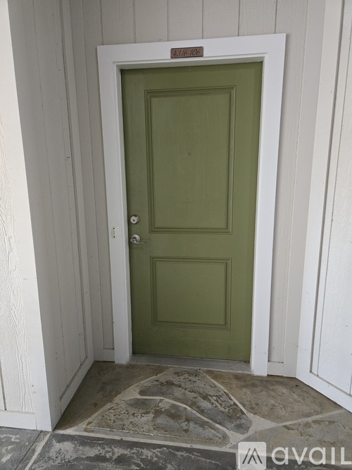 A green door is in a white room.