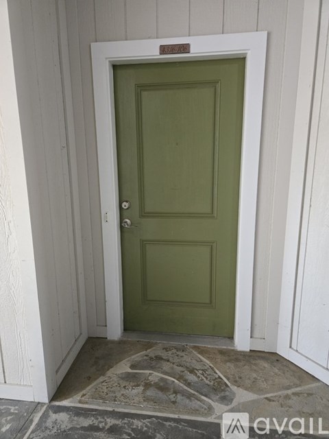 A green door is in a white room.
