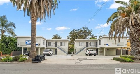 A row of houses with a blue sign in front of the first one.
