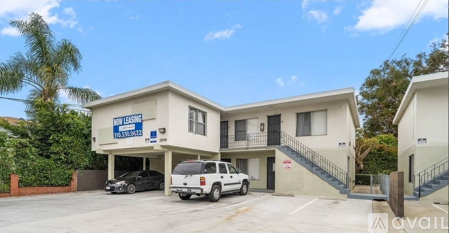 A two-story building with a sign that says "Now Leasing" is surrounded by a parking lot.