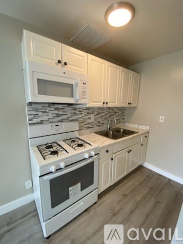 A kitchen with a stove, microwave, and oven.