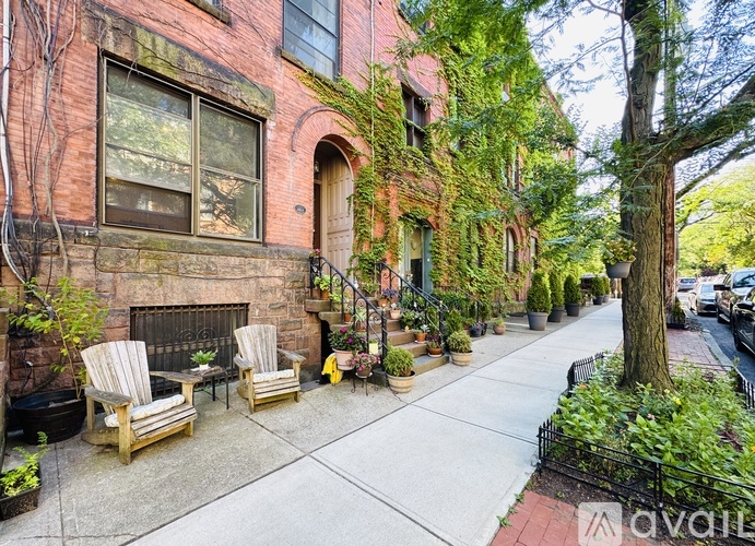 A red brick building with a tree in front of it.