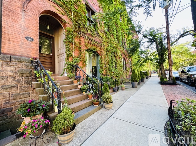 A red brick house with a green plant on the wall.