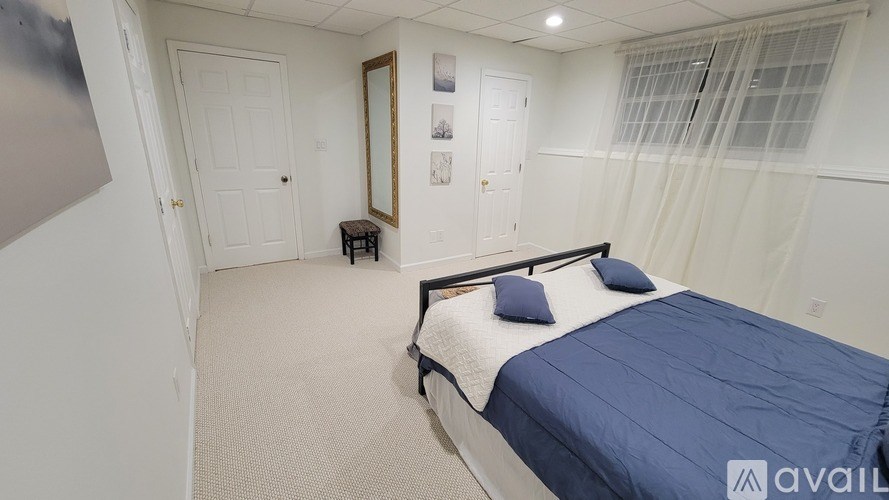 A bedroom with a bed, a mirror, and a small table.