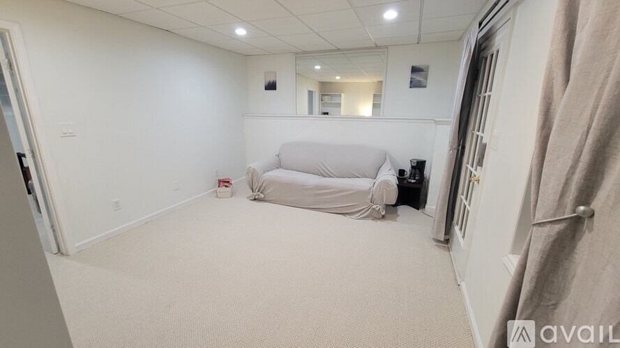 A bedroom with a bed, a mirror, and a towel rack.