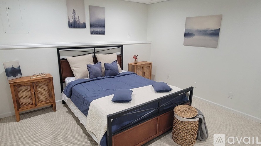 A bedroom with a large bed and a wooden nightstand.