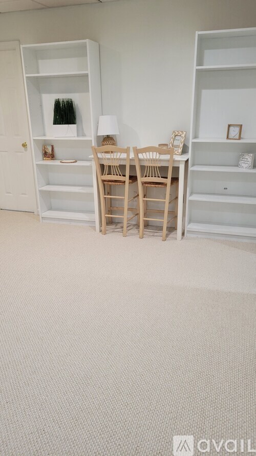 A room with a white chair and a white shelf.