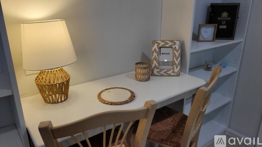 A table with a lamp, a basket, and a picture frame on it.