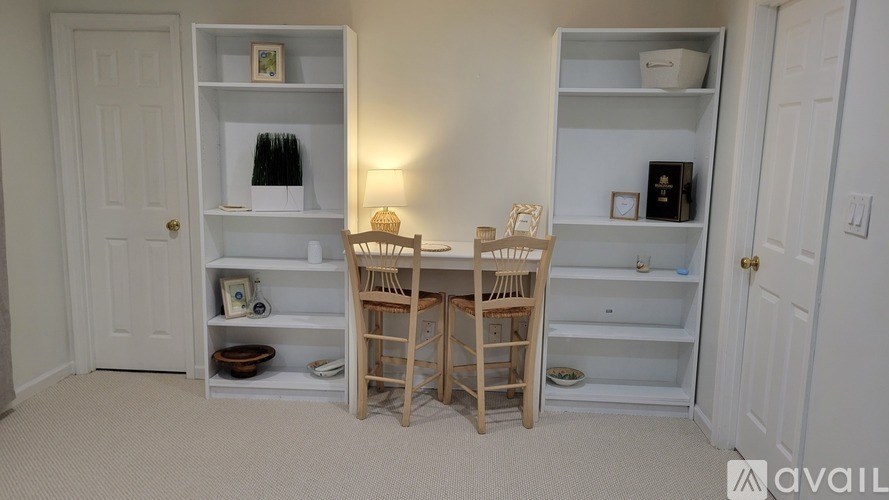 A room with two shelves and a table with chairs.