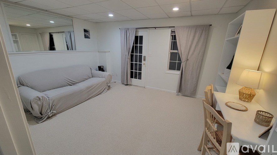 A living room with a grey sofa and a wooden chair.