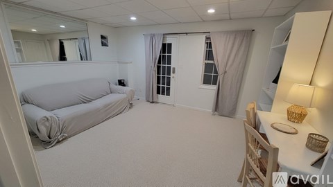A living room with a grey sofa and a wooden chair.