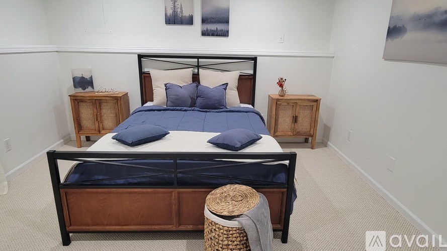 A bedroom with a bed, two nightstands, and a stool.