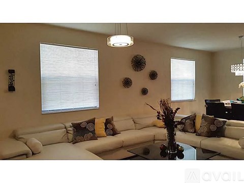 A living room with a white couch and a glass coffee table.
