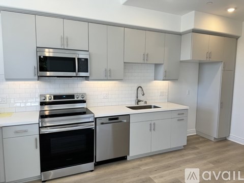 A kitchen with white cabinets and a stainless steel oven.