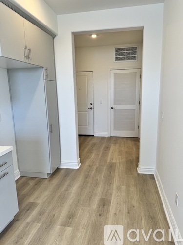 A hallway with wood flooring and white walls.