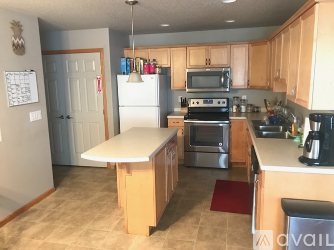 A kitchen with a white refrigerator, microwave, oven, and stove.