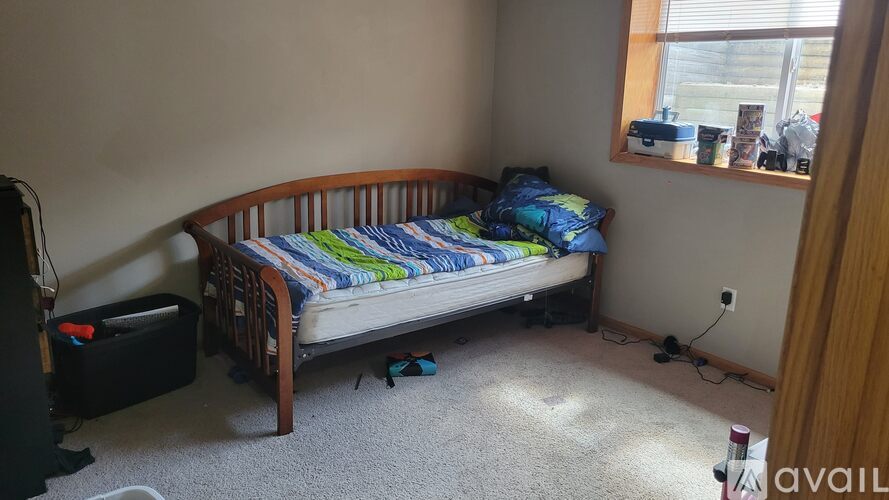 A bedroom with a bed, nightstand, and window.