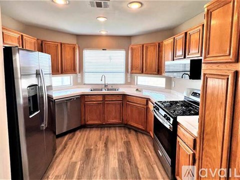 A kitchen with wooden cabinets and a refrigerator.