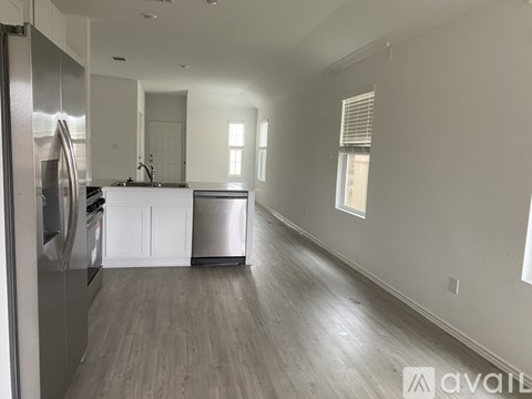 A kitchen with a refrigerator, stove, and dishwasher.