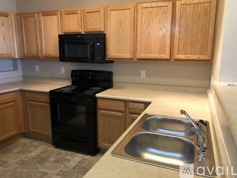 A kitchen with wooden cabinets and black appliances.