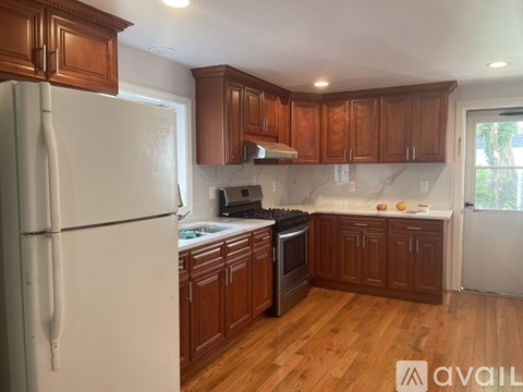 A kitchen with wooden cabinets and a white refrigerator.