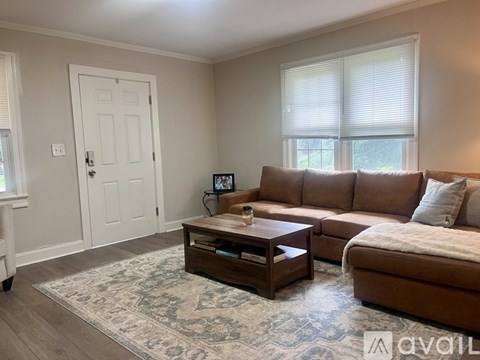A living room with a brown couch and a coffee table.