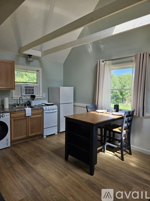 A kitchen with white appliances and wooden cabinets.