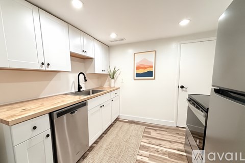A kitchen with white cabinets and a wooden countertop.