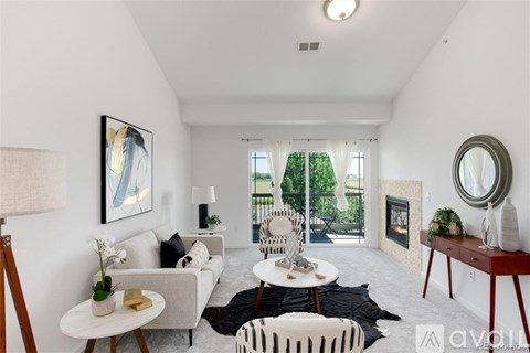 A living room with a white couch, a coffee table, and a painting on the wall.
