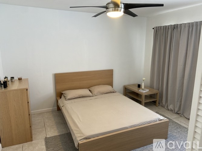 A bedroom with a large bed and a ceiling fan.