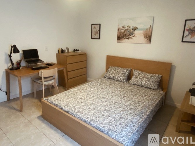 A bedroom with a bed, desk, and chair.