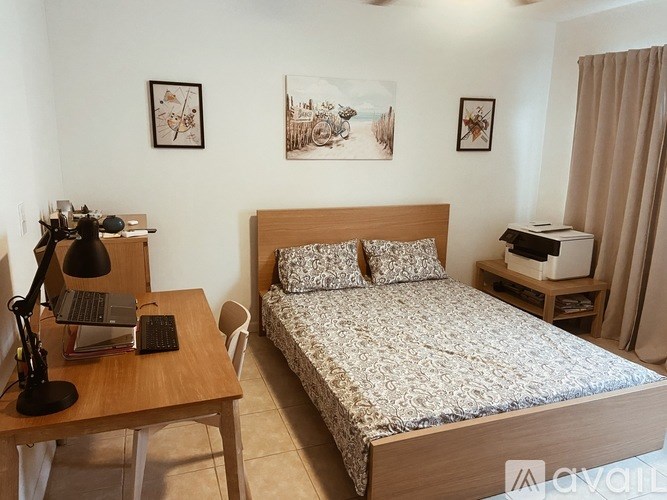 A bedroom with a bed, desk, and chair.