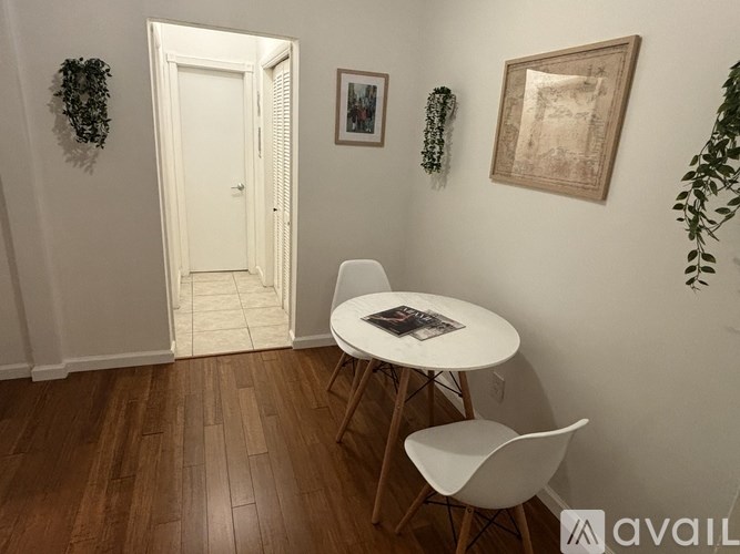 A white table with a chair in a room with a white door.