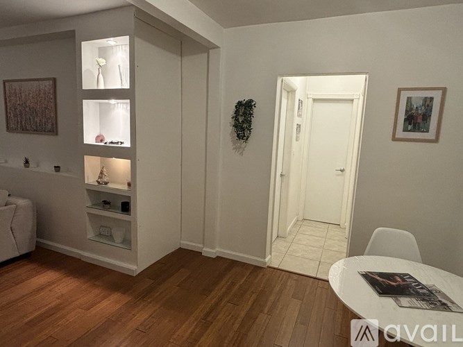 A living room with a white couch, a coffee table, and a white door.