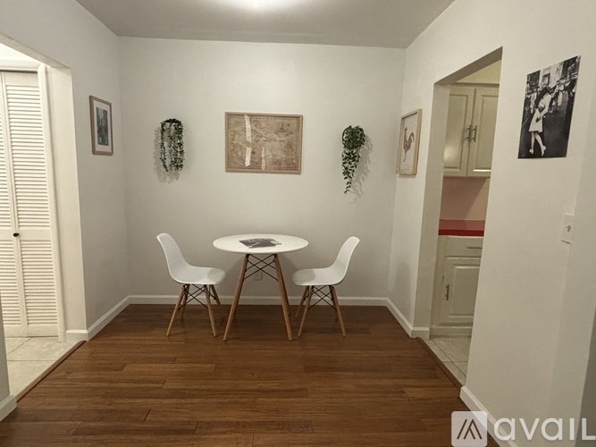 A dining room with a white table and chairs.