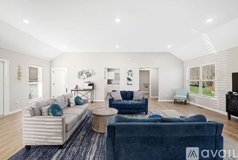 A living room with a blue couch and a white couch.