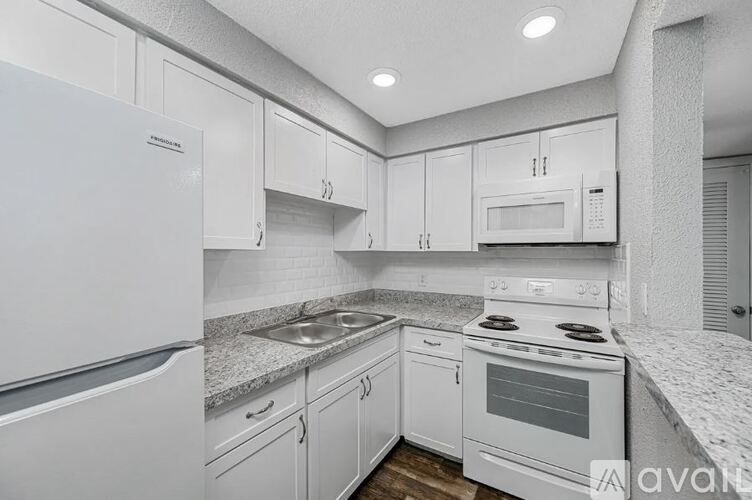 A kitchen with white appliances and cabinets.