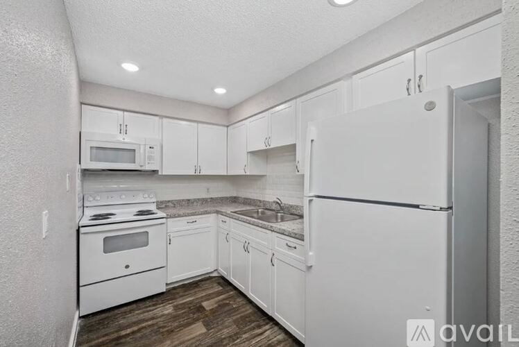 A kitchen with white appliances and cabinets.
