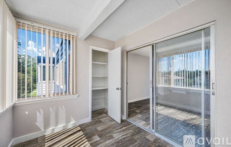 A room with a sliding glass door and a striped rug on the floor.