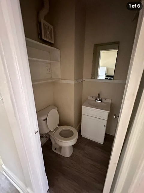 A white toilet and sink in a small bathroom.