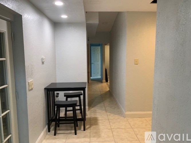A kitchen area with a table and chairs.